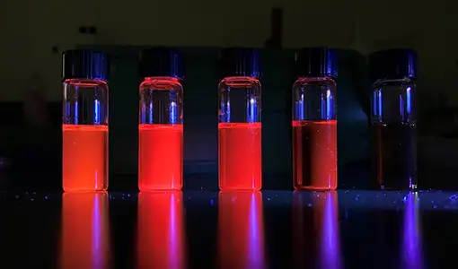 Image of five vials with glowing liquid inside.